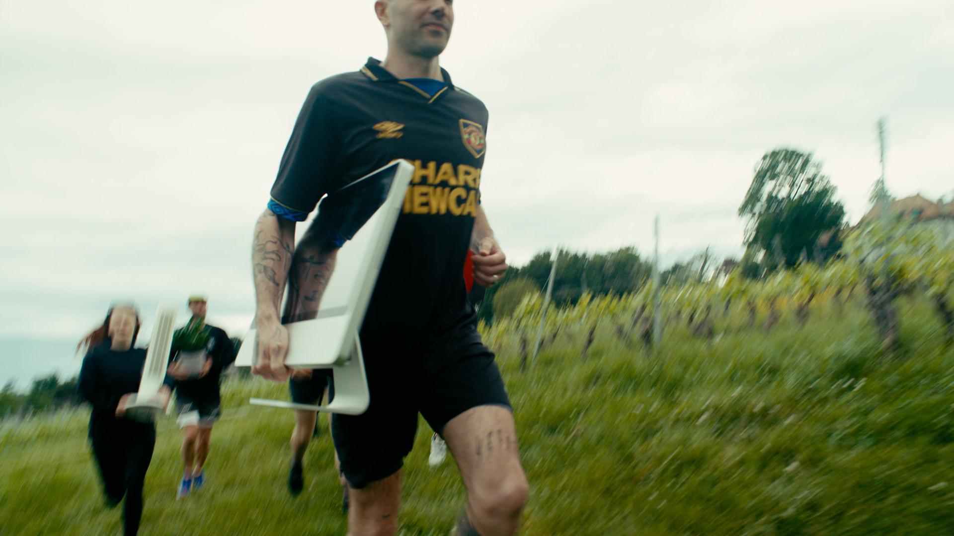 A runner carrying an office chair through a field during a PTO race