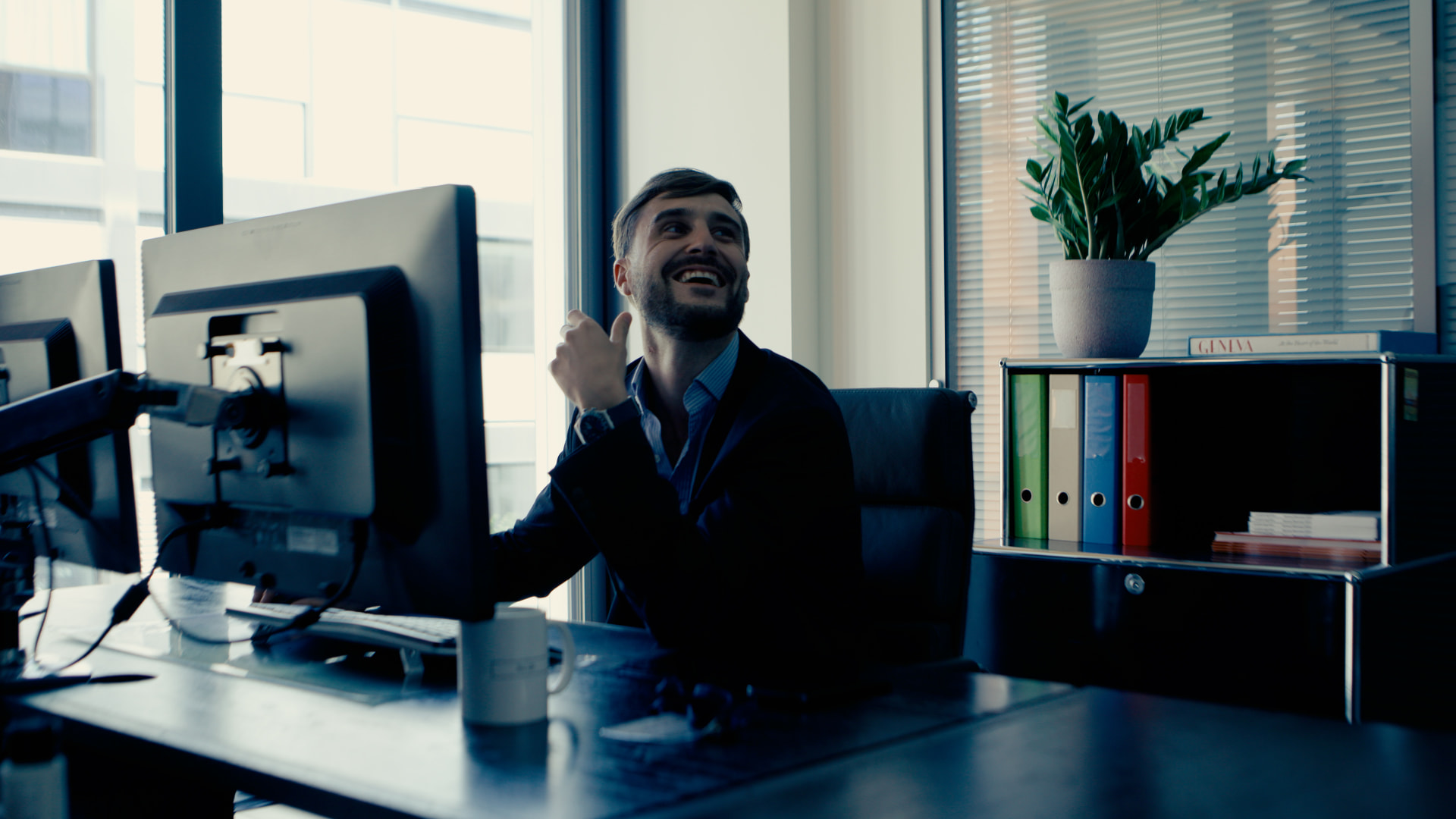 An office worker laughing at his desk before heading out to a PTO race