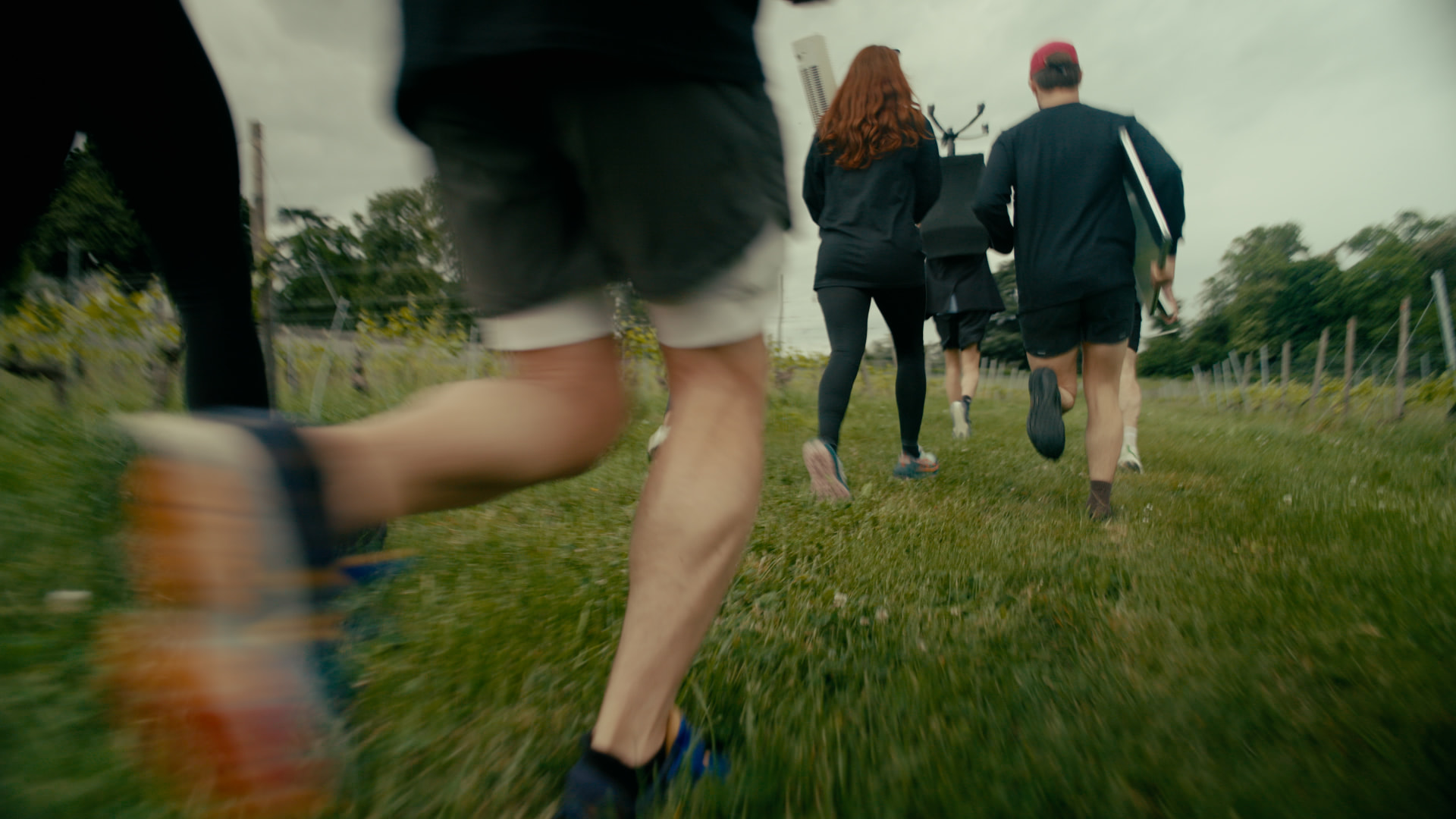Runners heading through a field carrying office equipment